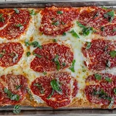 Square grandma pizza with mozzarella, tomato sauce, and basil