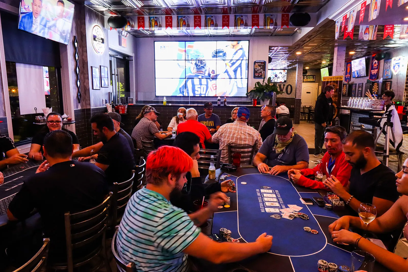 Sports bar with a row of televisions above the bar and liquor shelves